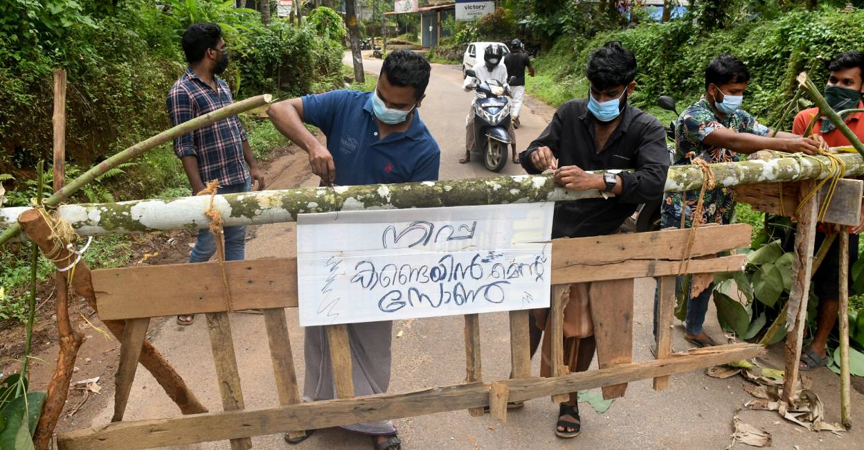 nipah-containemnt-zone Residents fix a sign reading 'Nipah containment zone' on a barricade, put up to block a road after the authorities declared the area a containment zone, to prevent the spread of Nipah virus at Ayanchery village in Kozhikode. Photo: Reuters