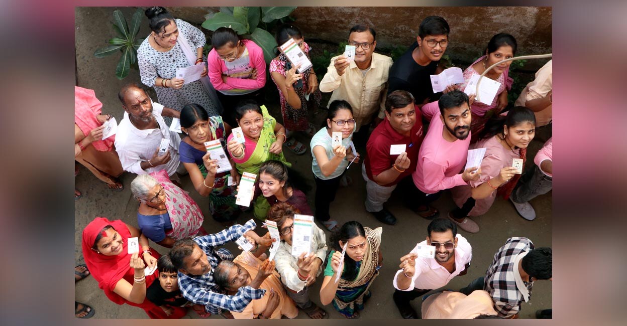 People wait in queues to cast their votes at a polling booth during the Maharashtra Assembly elections. Photo: PTI