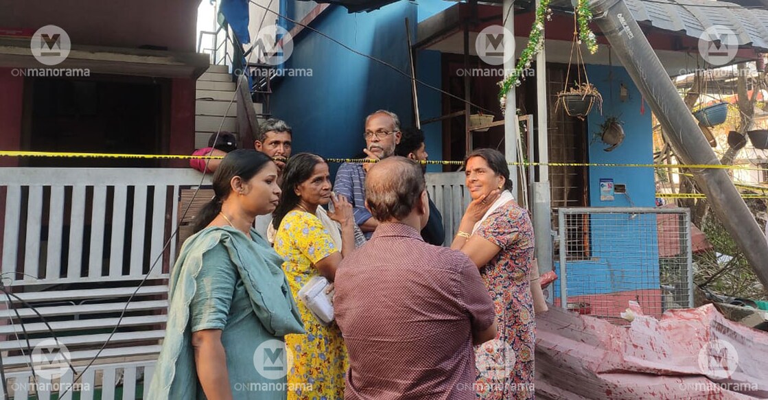 Beena (left) and Mani (yellow dress) with neighbours. The blue building is Beena's house. Photo: Onmanorama