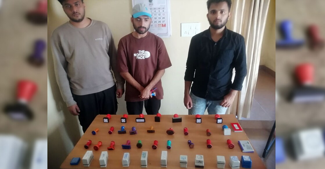 The trio pose with the fake seals after being arrested by the Bedakam Police in Kasaragod on Friday. Photo: Special arrangement