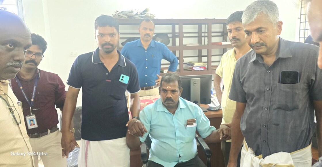 Ashokan (seated) was caught accepting the bribe around 3.20 pm on Tuesday. Photo: Special Arrangement