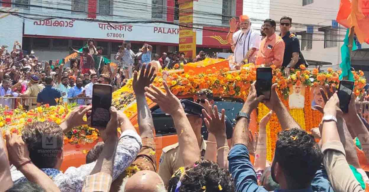 Prime Minister Narendra Modi waves at the public during a road-show in Palakkad. Photo: Manorama