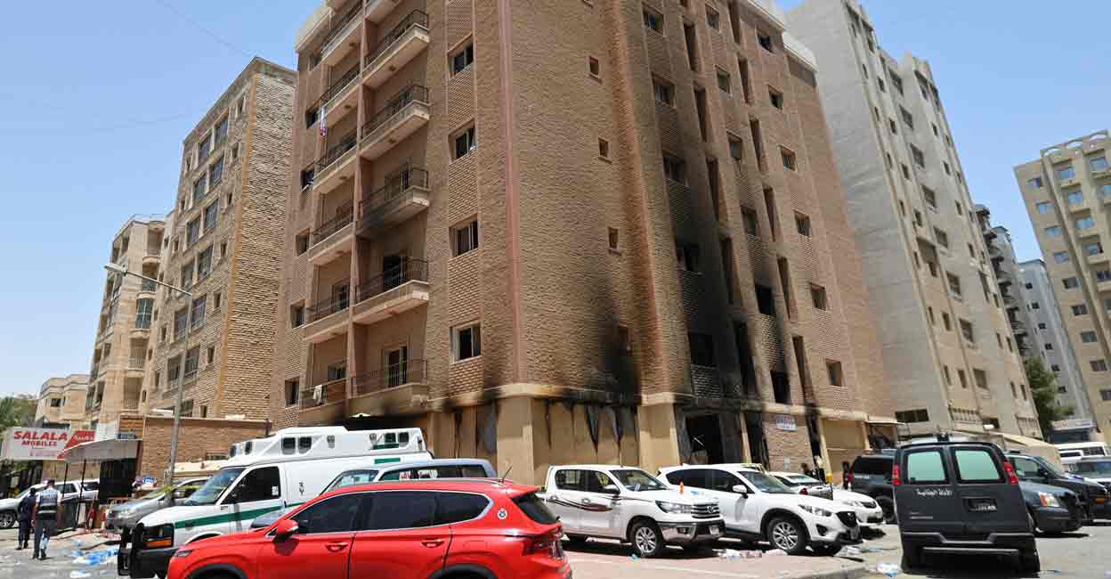 KUWAIT-FIRE Vehicles are parked next to a building damaged following a deadly fire, in Mangaf, southern Kuwait, June 12, 2024. Photo: REUTERS/Stringer