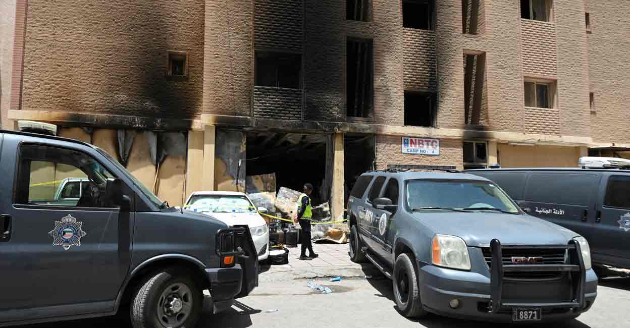 A Kuwaiti police officer is seen in front of a burnt building following a deadly fire, in Mangaf, southern Kuwait, June 12, 2024. Photo: REUTERS/Stringer

