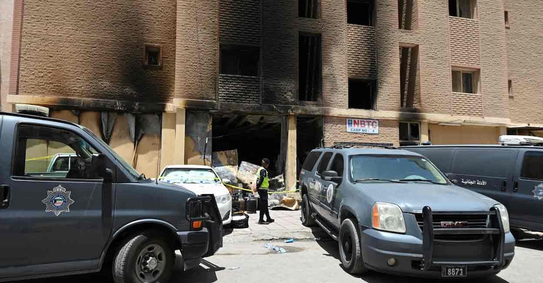 A Kuwaiti police officer is seen in front of a burnt building following a deadly fire, in Mangaf, southern Kuwait, June 12, 2024. Photo: REUTERS/Stringer


