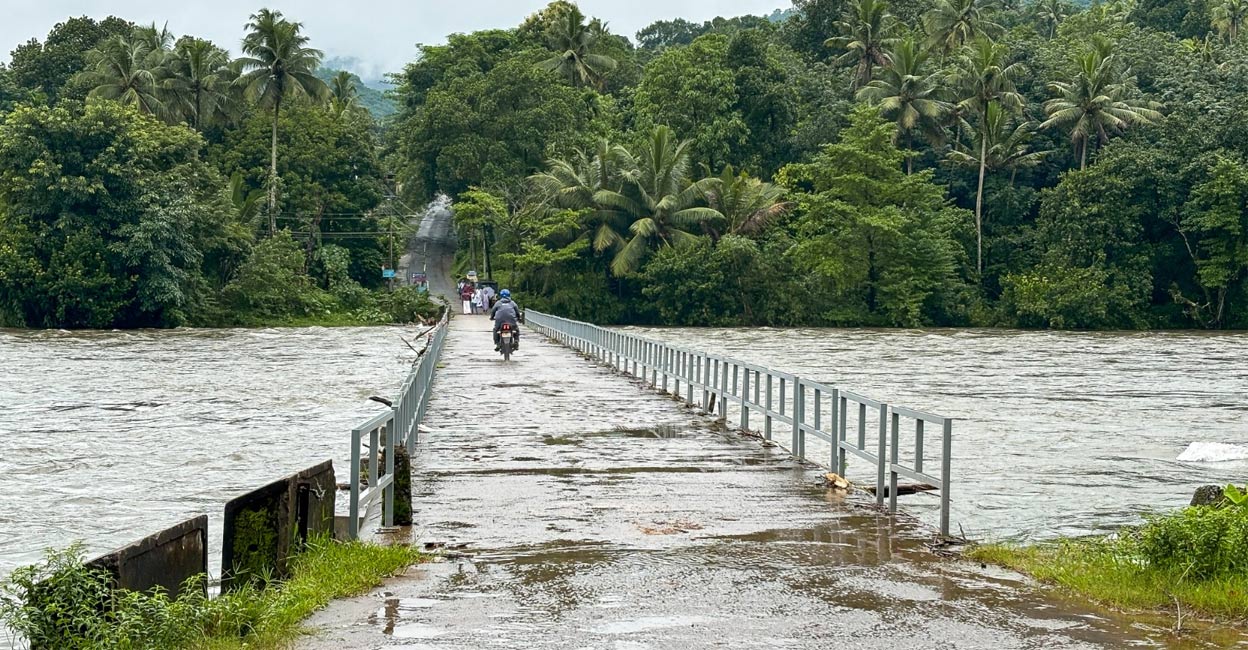 As the river swells, it submerges the concrete bridge, the sole line of connectivity for Arayanjilimon residents to the outside world. Photo: Tijin VS. 