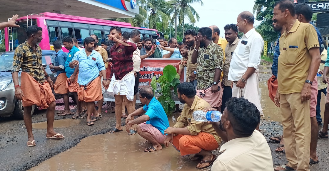 Protesters sitting in the muddy water of the gutters to draw the government's attention to the issue. Photo: Special Arrangement.