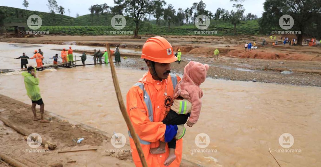 A volunteer carries an infant to safety from landslide-hit Chooralmala in Wayanad on July 31. Photo: Onmanorama/Albin Mathew