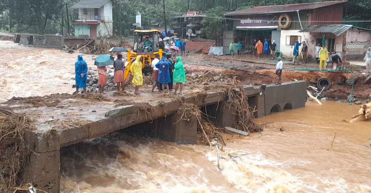 landslide-debris-manjacheli-vilangad Volunteers stand on a makeshift bridge constructed at Vilangad. Photo: Special arrangement
