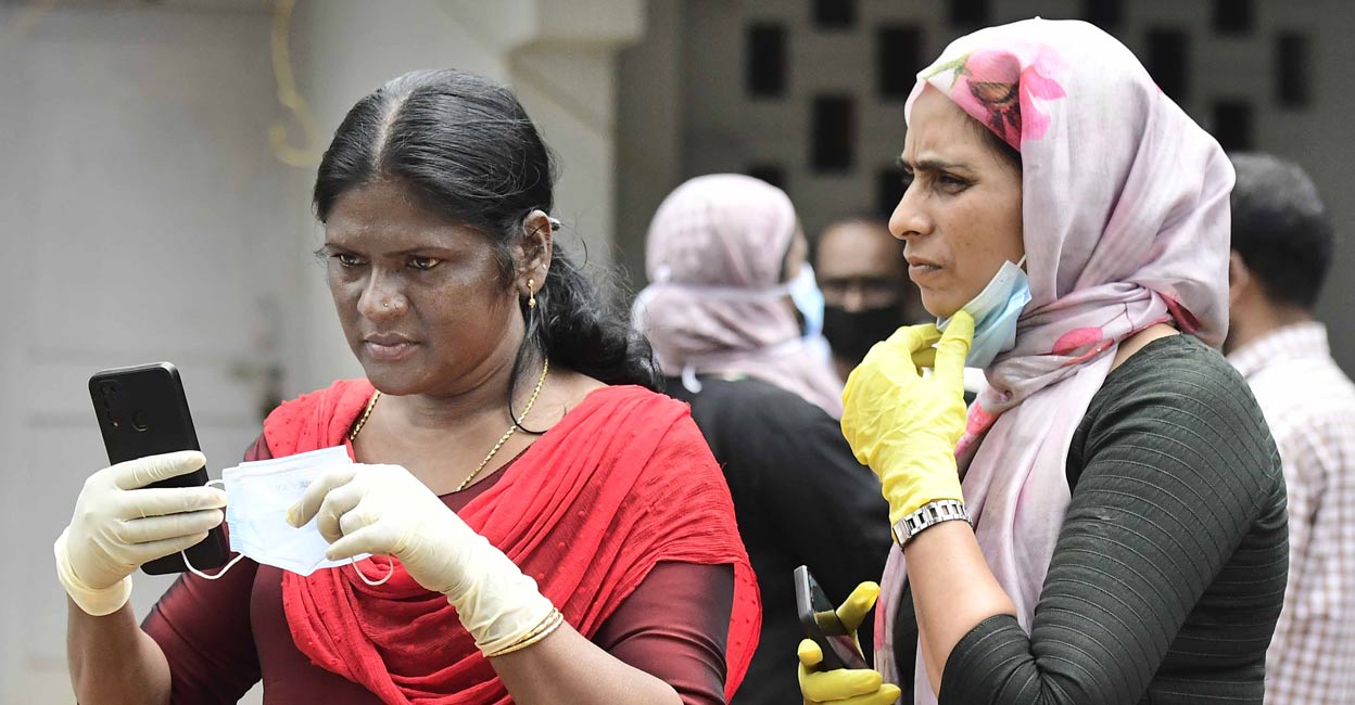Former panchayat members Shaija Baby (left) and Seenath C meticulously going through the details of the deceased to help identify them for their families at Meppadi Family Health Centre. Photo: Special Arrangement
