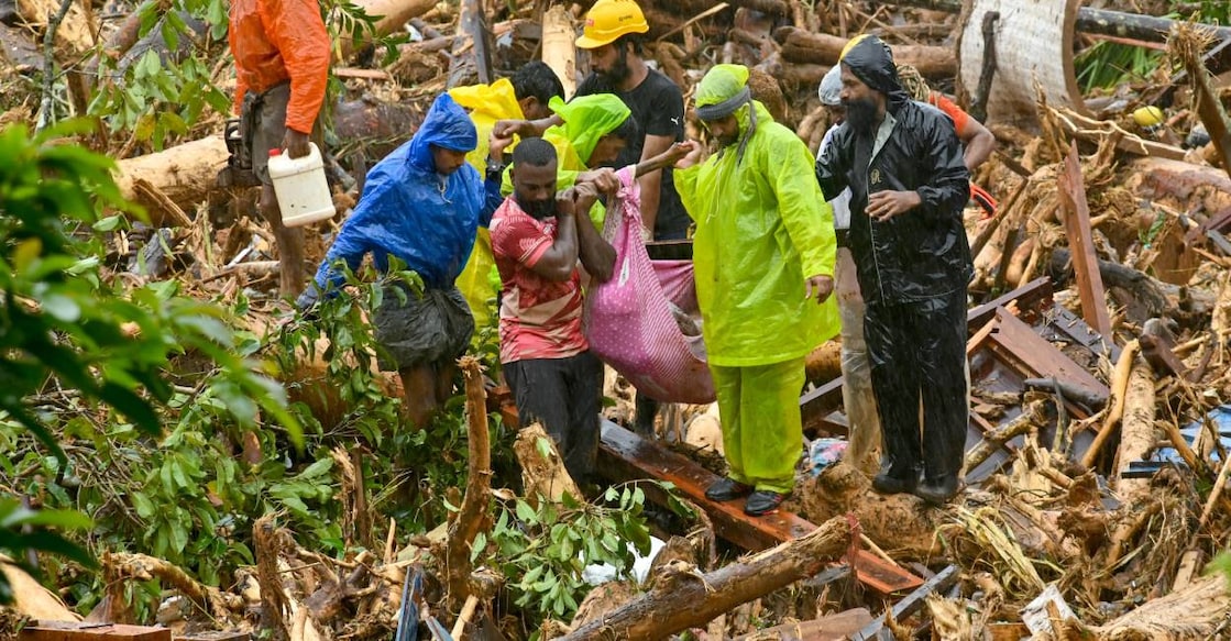 Relief personnel carry the body of a victim, during a search and rescue operation at Mundakkai. Photo: AFP