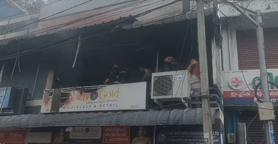 Fire and Rescue Service personnel douse the fire at an insurance office in Pappanamcode. Photo: Manorama