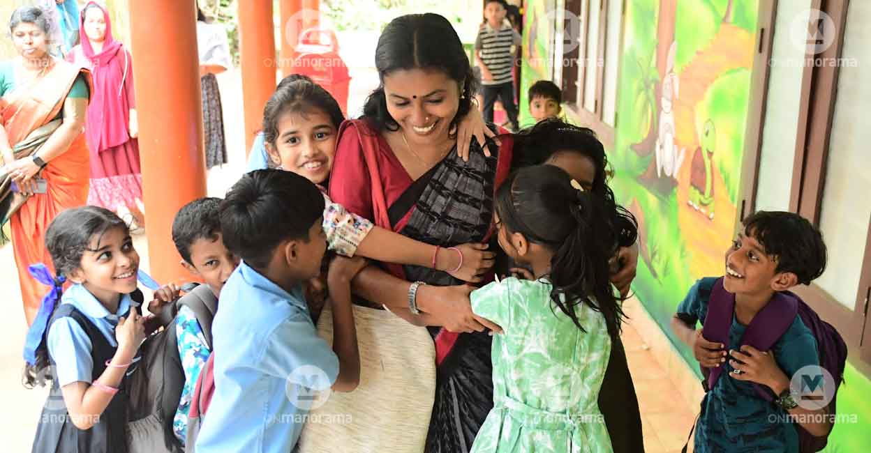 Shalini Thankachan is hugged by her students as she returned to the Government LP School at Mundakkai in Wayanad. Photo: Dhanesh Ashokan/Manorama