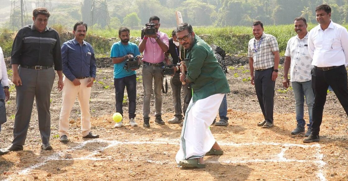 Minister Rajesh plays cricket on a pitch marked in the cleared portion of the Brahmapuram waste dumping yard. Photo: Special Arrangement
