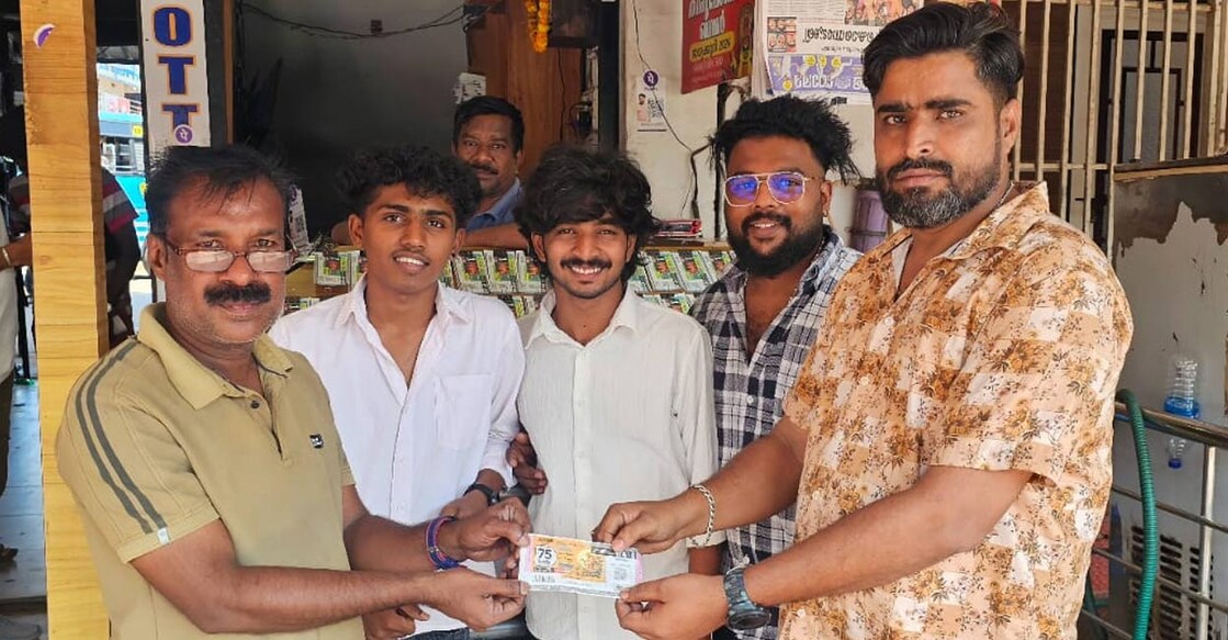 T V Vinod (right) of Sam Sam Lottery House and his staff handing over the lost and found ticket to Raghu Kannan (left) in Kanhangad. Photo: Special Arrangement.