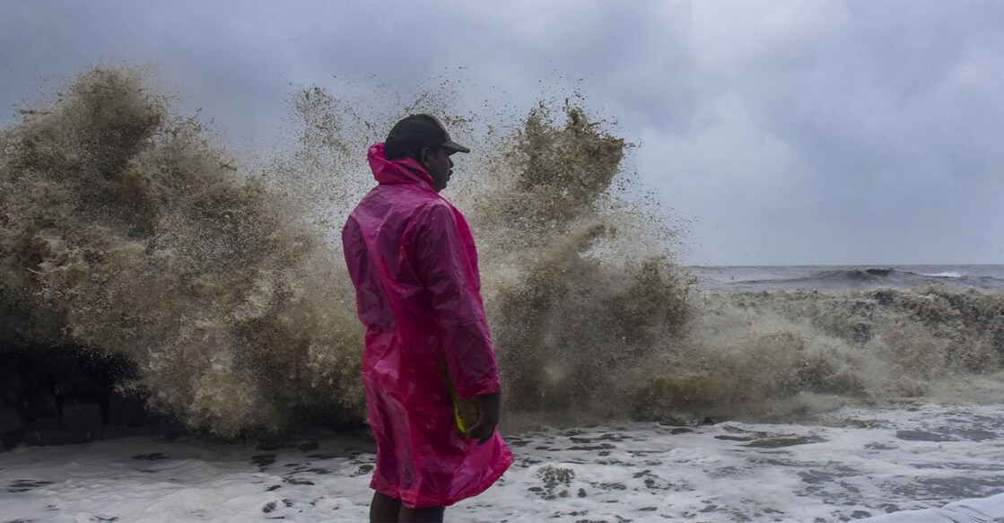A man watches as sea waves crash against the shore during monsoon season, at Vypin Beach in Kochi. Photo: PTI