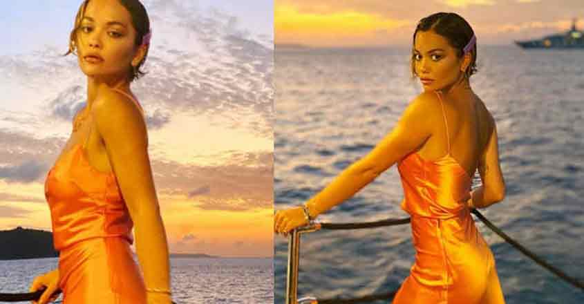 Singer Rita Ora went braless in an orange satin gown during the festive season. Singer Rita Ora went braless in an orange satin gown during the festive season.