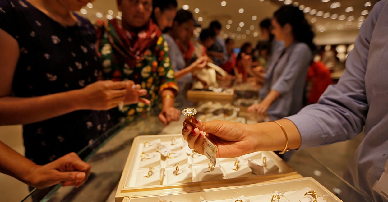 A salesperson shows a gold ring to customers at a jewellery showroom during Dhanteras. File photo: Reuters/Amit Dave