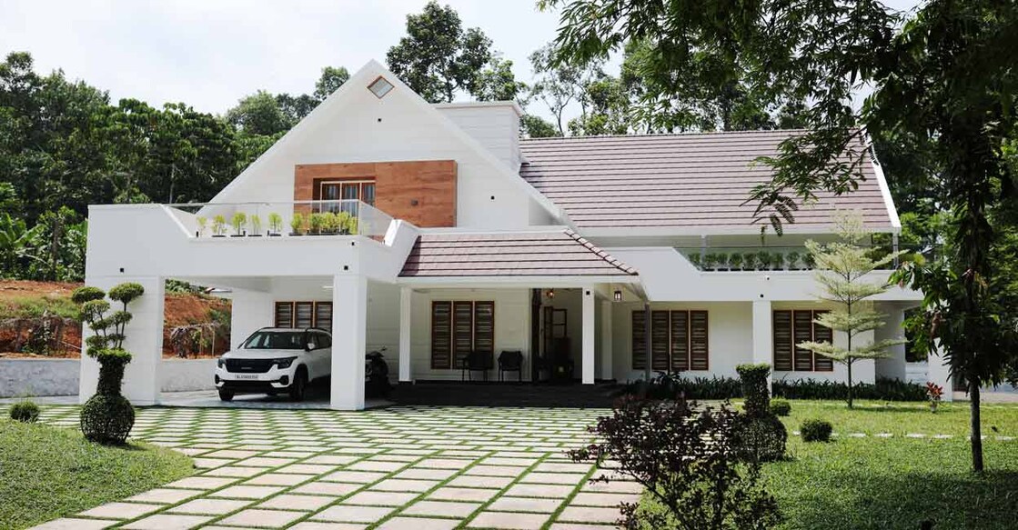 The house stands in a sprawling one-acre land that is surrounded by lush greenery.
