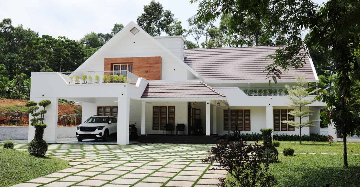 The house stands in a sprawling one-acre land that is surrounded by lush greenery.