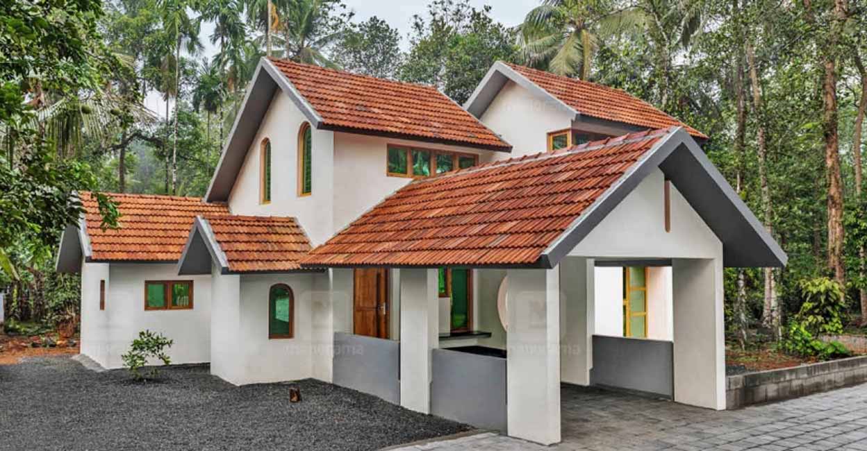 The house stands in the centre of a plot that is surrounded with lush greenery.