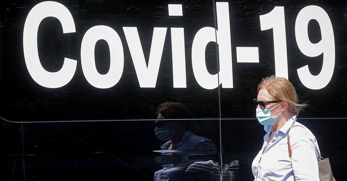 A woman wearing a mask passes by a coronavirus disease mobile testing van in Washington Square Park in New York City. Photo: REUTERS/Brendan McDermid