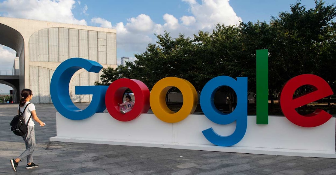 A woman and her child play on a Google sign. Image courtesy: Johannes EISELE / AFP