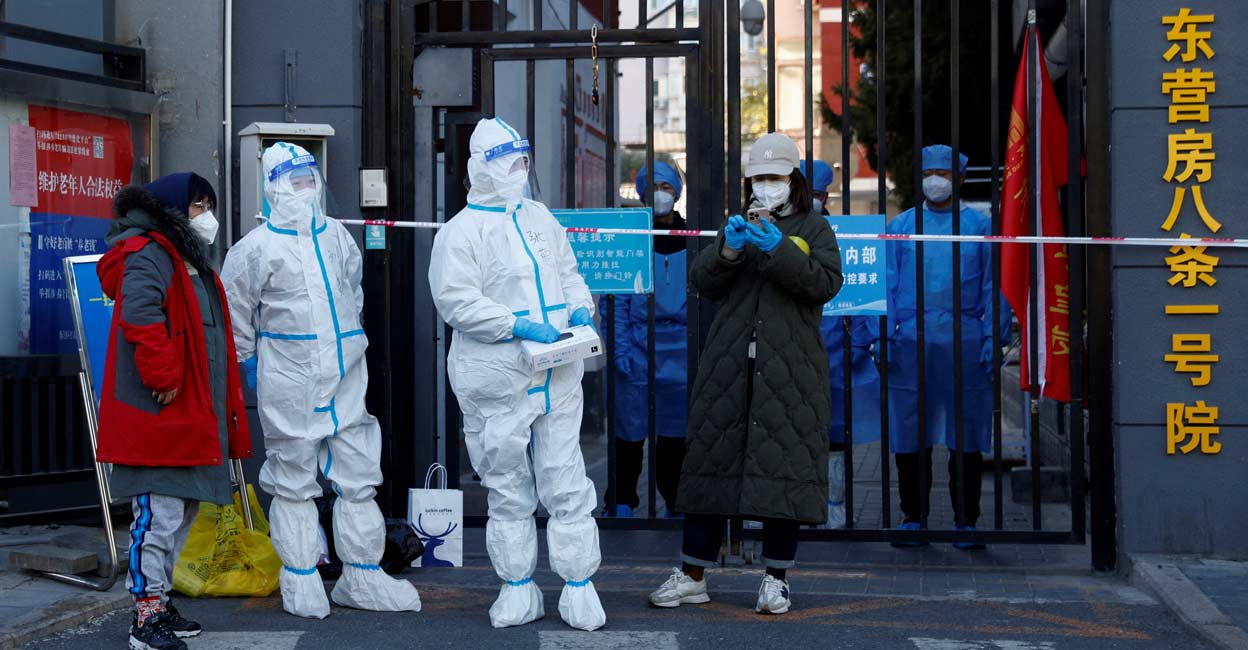Security personnel in protective suits stand at the gate of a residential compound that is under lockdown. Representative image: REUTERS/Thomas Peter/File Photo