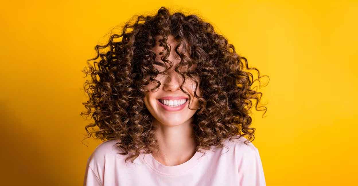Curly hair naturally attracts moisture and dirt from the environment. Photo: Shutterstock/Samborskyi