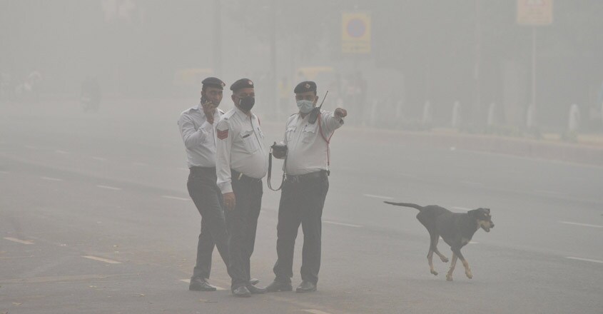 New Delhi: Traffic police personnel wear masks to protect themselves from pollution as smog engulfs New Delhi on Nov 3, 2019. (Photo: IANS)