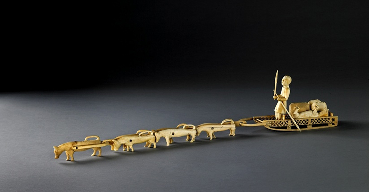 Carved ivory model group of a dog sled.