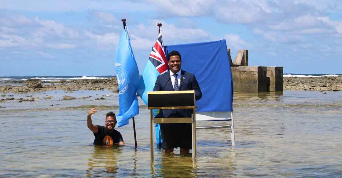 Tuvalu's Minister for Justice, Communication & Foreign Affairs Simon Kofe gives a COP26 statement while standing in the ocean in Funafuti, Tuvalu. Courtesy: Tuvalu's Ministry of Justice, Communication and Foreign Affairs / Social Media via Reuters