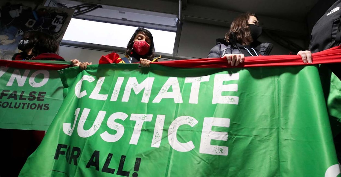 People hold a banner during a protest at the UN Climate Change Conference (COP26), in Glasgow, Scotland. Photo: Reuters/Yves Herman