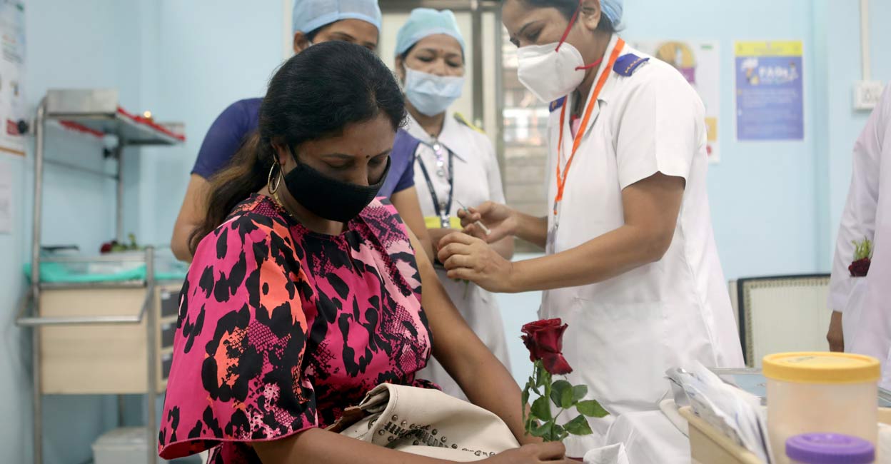 A healthcare worker holding a rose is vaccinated against COVID-19 at a medical centre in Mumbai, India, January 16, 2021. REUTERS/Francis Mascarenhas/File Photo