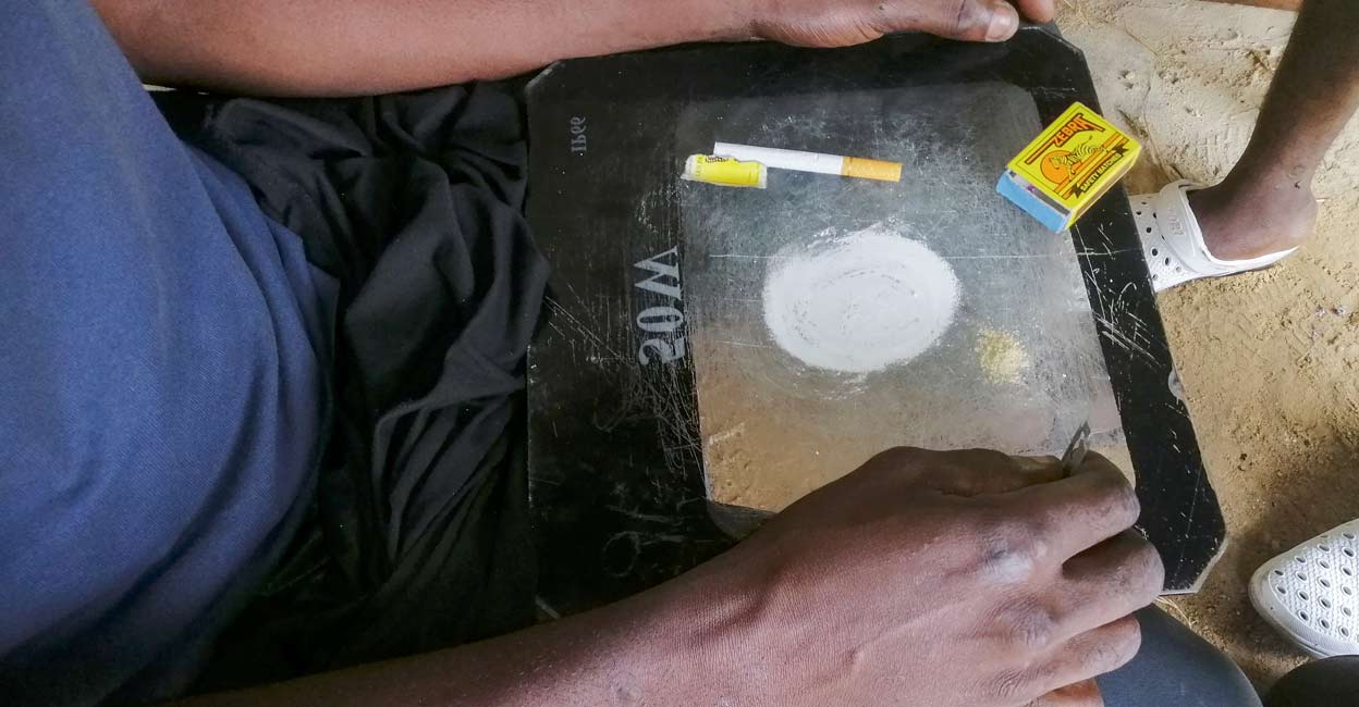 A man shows a substance known as 'bombe', a mix of catalytic converters' crushed honeycomb and pills, before snorting it, in Kinshasa. Image courtesy: REUTERS/Benoit Nyemba