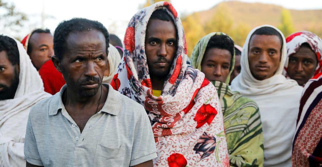 Men stand in line to receive food donations, at the Tsehaye primary school, which was turned into a temporary shelter for people displaced by conflict, in the town of Shire, Tigray region, Ethiopia. REUTERS/Baz Ratner