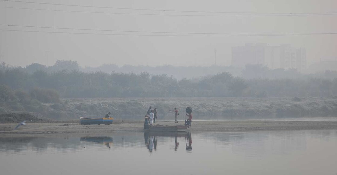 A couple poses for a photo on the banks of Yamuna river on a smoggy morning in the old quarters of Delhi. Reuters/Adnan Abidi/File Photo