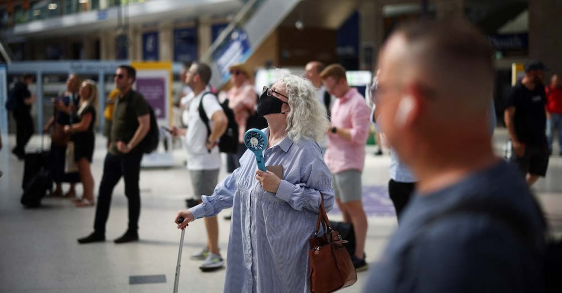 EUROPE-WEATHER-BRITAIN A woman cools herself with a portable fan, during a heatwave, in London, Britain. Photo: Reuters/Henry Nicholls