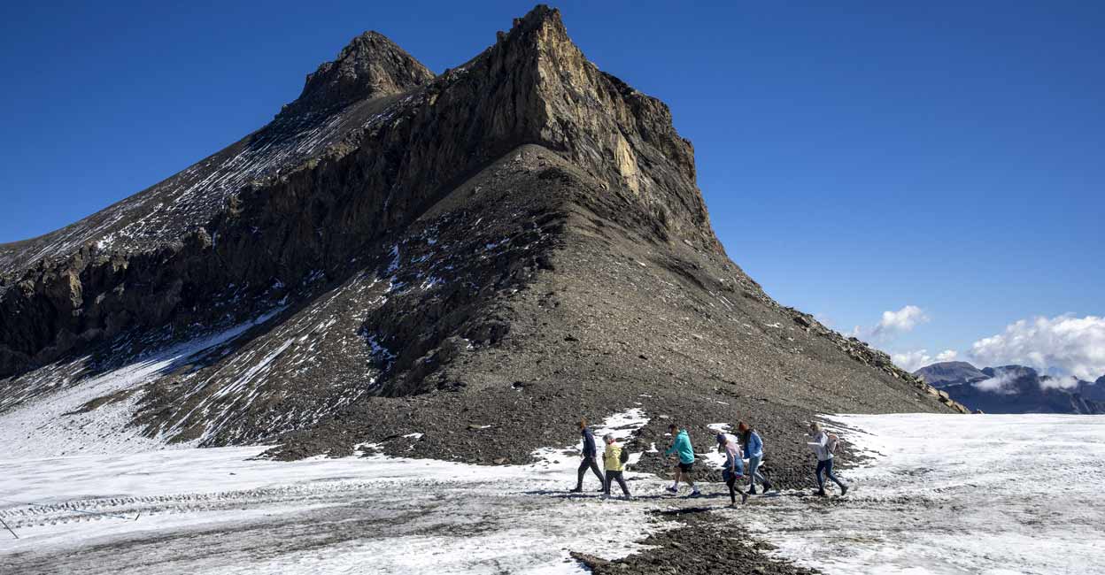 Hikers walk past the newly uncovered Zanfeluron path, as a split of the Sex-Rouge and the Zanfleuron Glacier revealed the path for the first time in 2000 years due to this summer heatwave, at Glacier 3000 in Les Diablerets, Switzerland, September, 2022. Photo: REUTERS/Denis Balibouse
