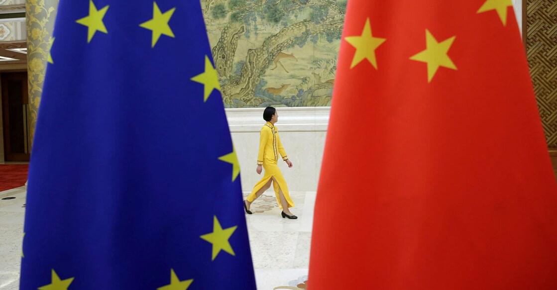 An attendant walks past EU and China flags ahead of the EU-China High-level Economic Dialogue at Diaoyutai State Guesthouse in Beijing. Photo Reuters/Jason Lee/File