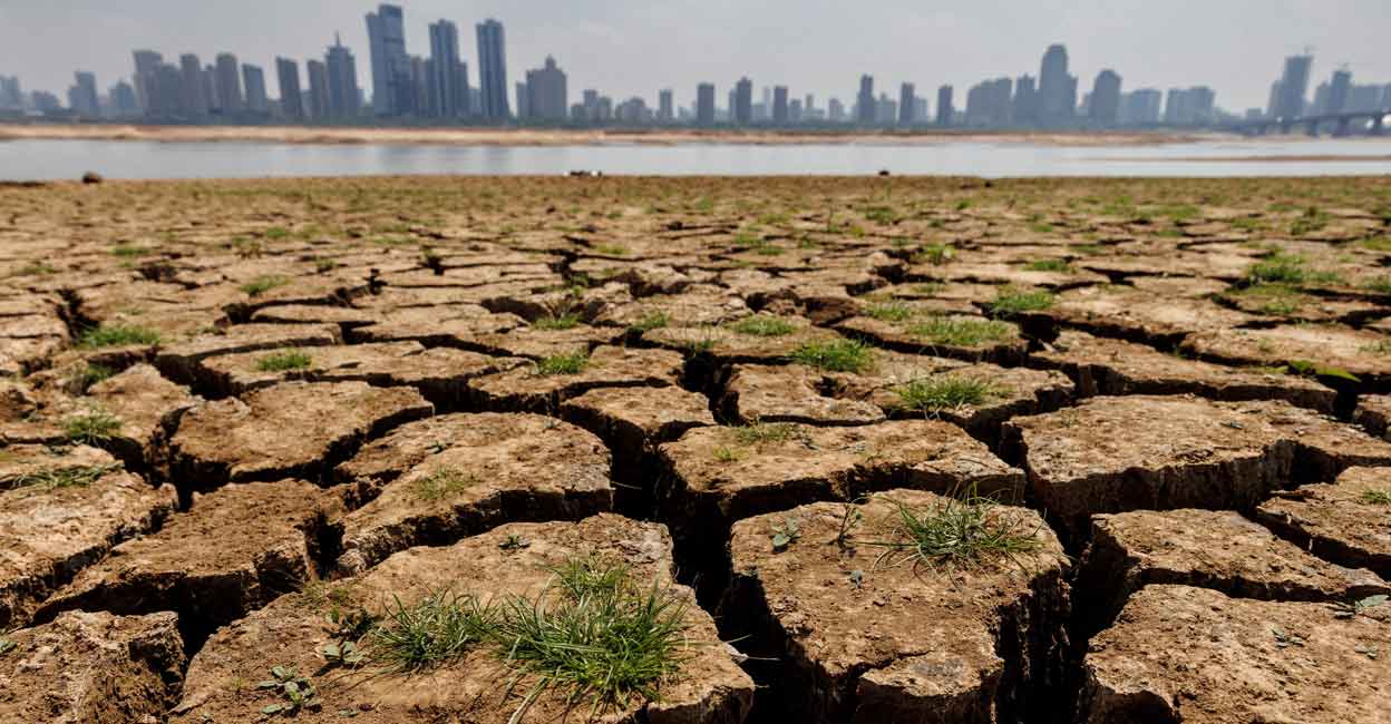 Cracks run through the partially dried-up river bed of the Gan River, a tributary to Poyang Lake during a regional drought in Nanchang, Jiangxi province, China, August 28, 2022. Photo: Thomas Peter/File 