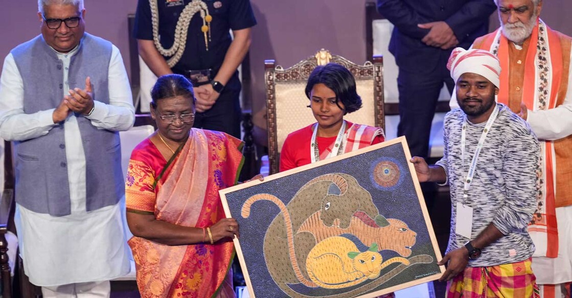 President Droupadi Murmu with artists during the inaugural function of the art exhibition in New Delhi, Friday. Union Minister Bhupender Yadav and Union MoS Ashwini Kumar Choubey are also seen. Photo: Kamal Singh/PTI