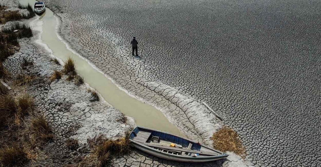 Manuel Flores walks on a dry area that shows the drop in the level of Lake Titicaca, Latin America's largest freshwater basin, as it is edging towards record low levels. Photo: Reuters/Claudia Morales/File