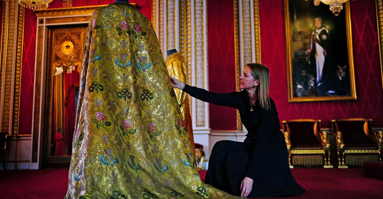 BRITAIN-ROYALS-CORONATION-VESTMENTS Caroline de Guitaut, deputy surveyor of the King's Works of Art for the Royal Collection Trust, adjusts the Imperial Mantle. Photo: Victoria Jones/Pool via Reuters