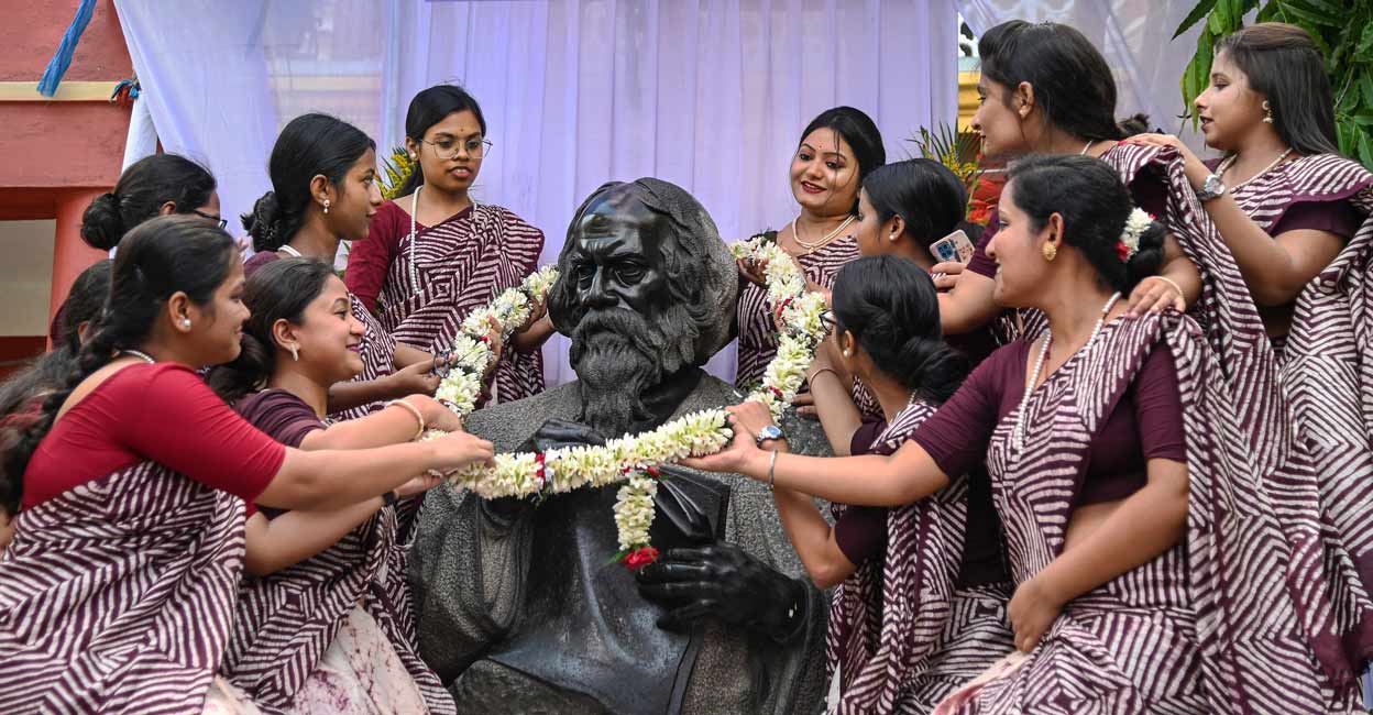 Students of Rabindra Bharati University garland a statue of Nobel laureate poet Rabindranath Tagore on the eve of his birth anniversary, at his ancestral house 'Jorasanko Thakurbari', in Kolkata on Monday. Photo: PTI Photo