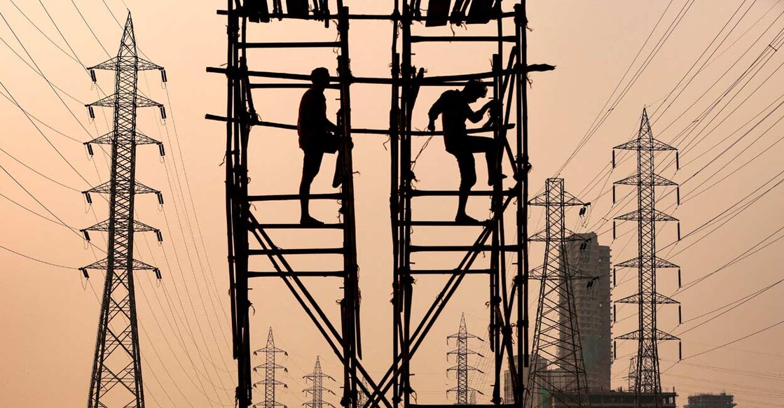 Labourers work next to electricity pylons in Mumbai. Photo: Reuters/Francis Mascarenhas/File