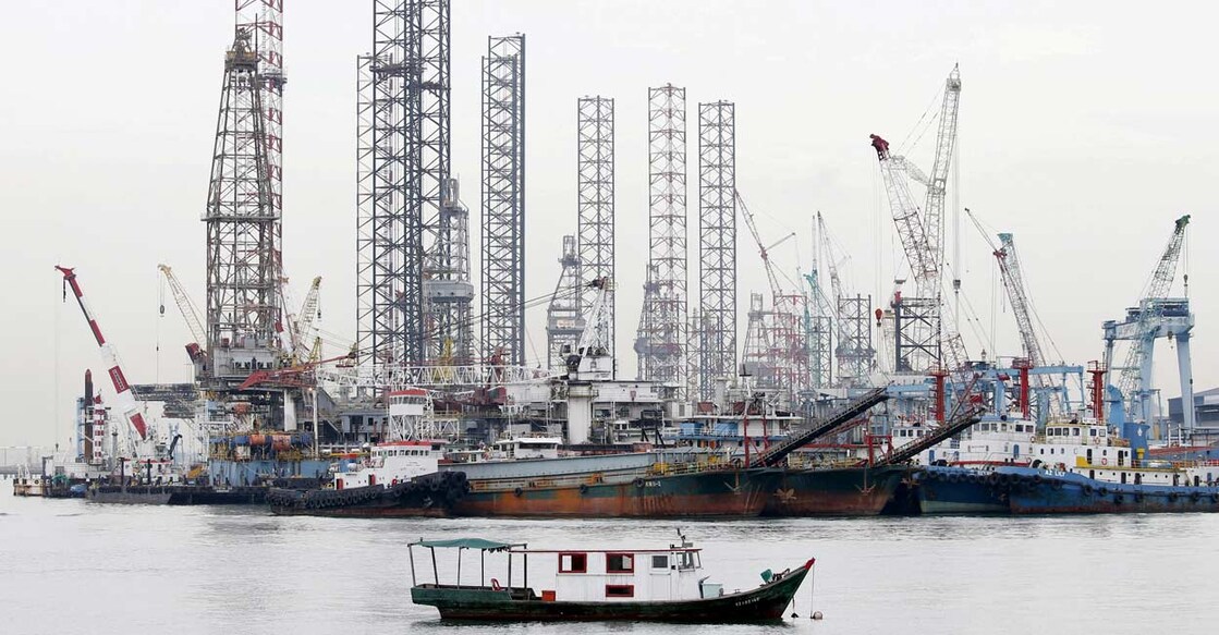 Offshore drilling platforms (rear) stand together at a dockyard near Singapore port. Photo: Reuters/Tim Wimborne//File