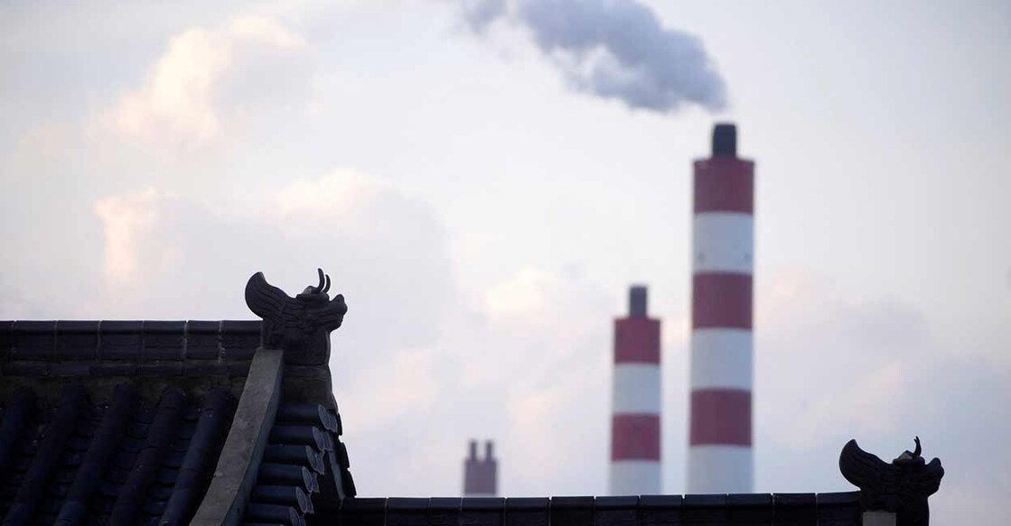 Chimneys of a coal-fired power plant are seen behind a gate in Shanghai, China. Photo: REUTERS/Aly Song/File Photo