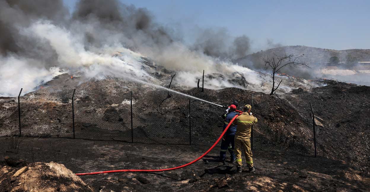 CLIMATE-CHANGE-WILDFIRE-TEMPERATURE Firefighters try to extinguish a fire burning at a recycling plant, in Sesklo, in central Greece. Reuters/Alexandros Avramidis/File Photo