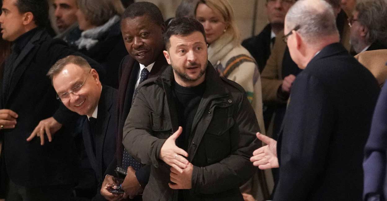 FRANCE-NOTREDAME Ukraine's President Volodymyr Zelenskiy shakes hands with a guest in Notre-Dame de Paris Cathedral, during the re-opening of the Cathedral. Photo: Thibault Camus/Pool via REUTERS